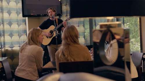 Live music event with a young man singing and playing guitar